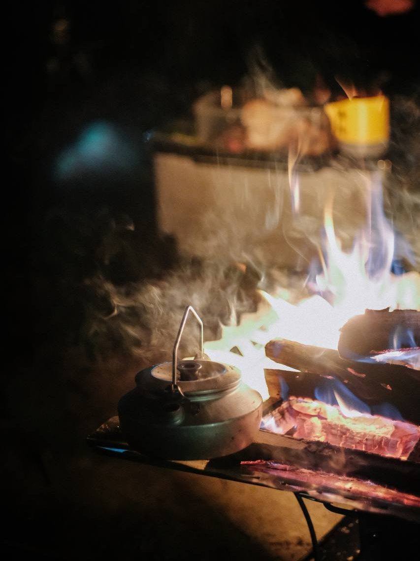 SOTO ST-940 firepit with fire burning on kettle at campsite